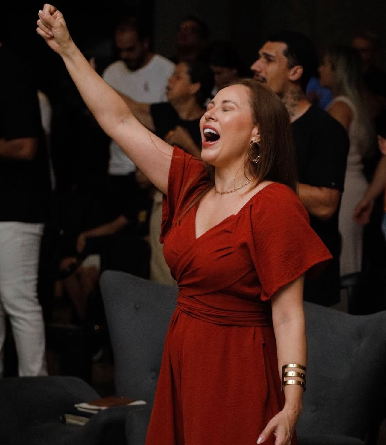 Mulher adorando durante o culto na Vitória da Fé